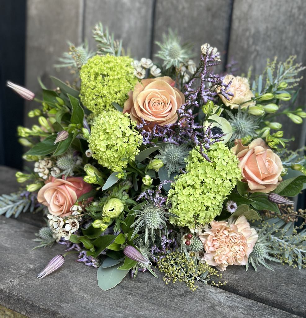 Floras signatur buket i grønne, creme og lyserøde nuancer. 