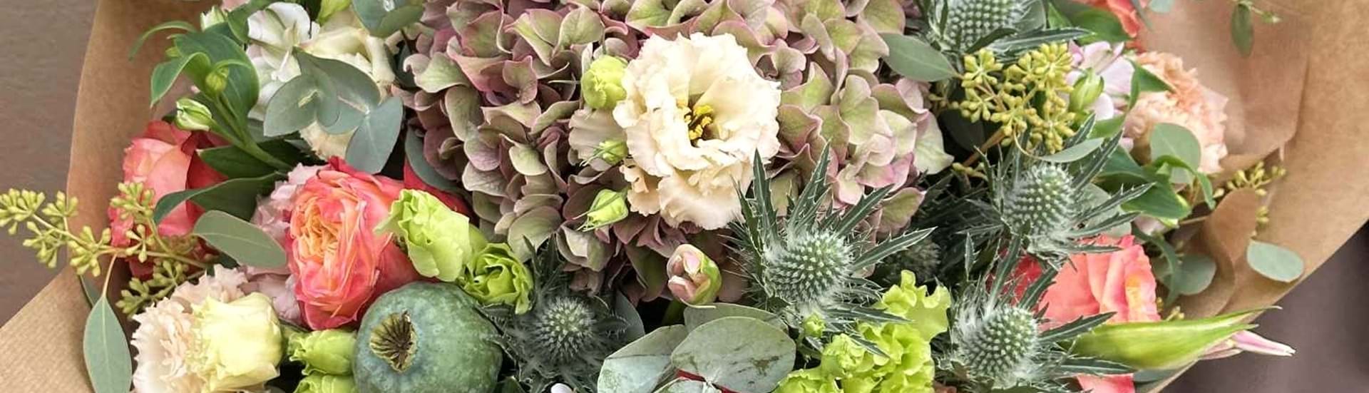 Floras pasteldrøm buket med blomster i smukke pastelfarver. Buketten er bundet tæt og fyldig, og har et afdæmpet roligt udtryk.