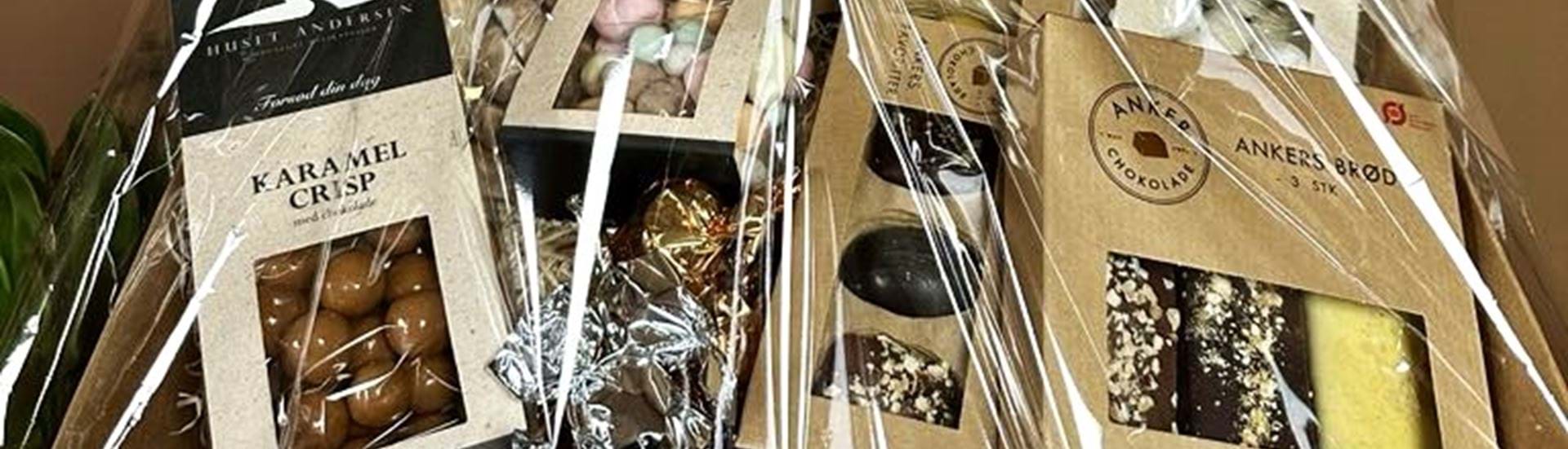 Gavekurv fyldt med karameller, romkugler, chokolade, chips og andet slik.