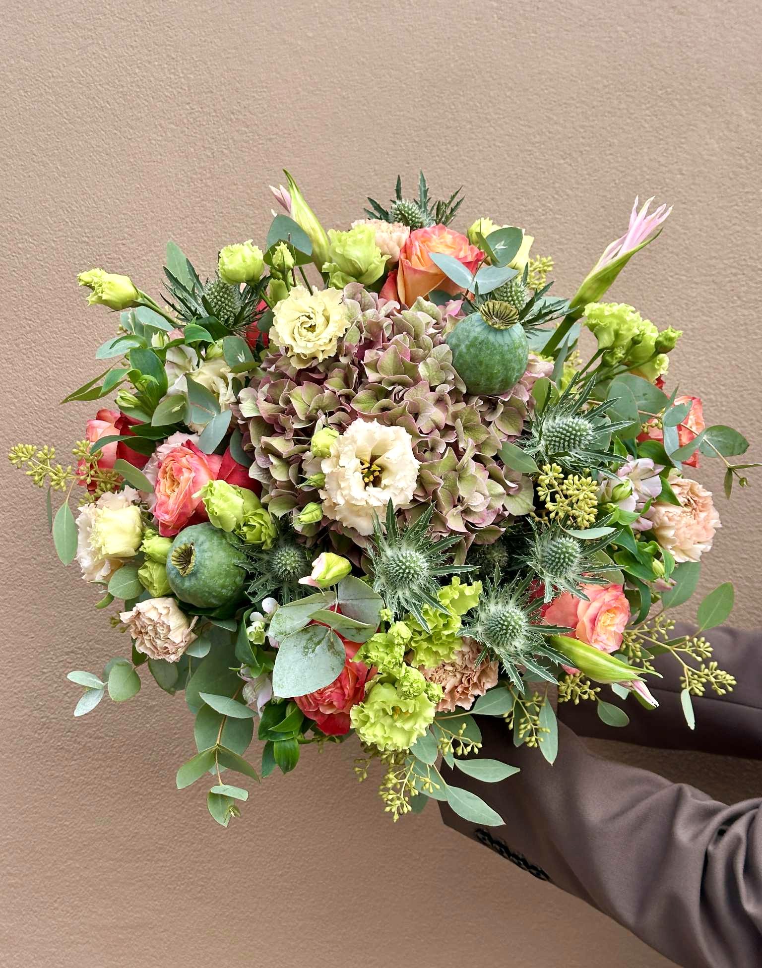 Tæt og fyldig buket bundet med blomster i forskellige pastelfarver. 