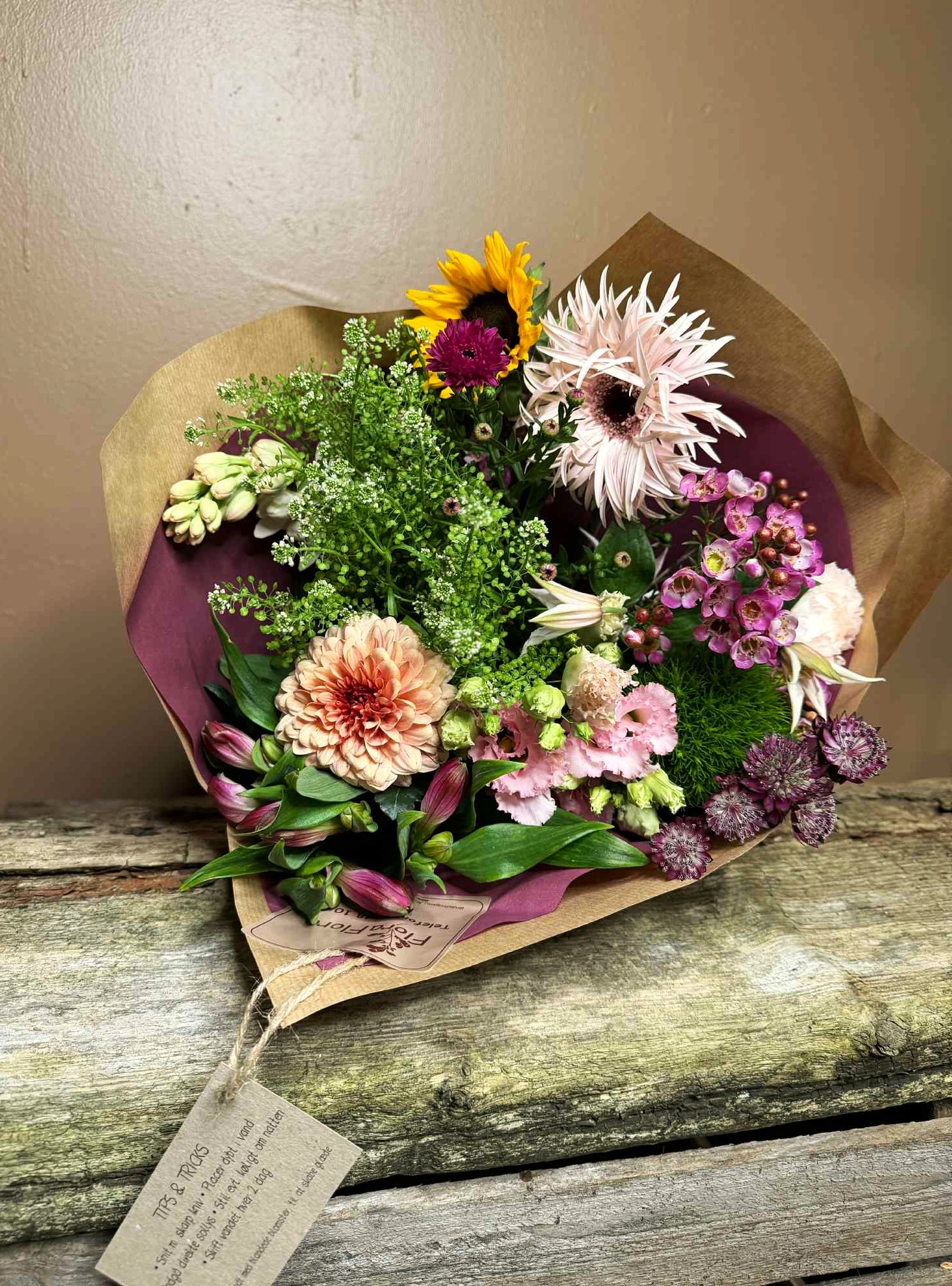 Floras Hygge Bundt er fyldig og farverig buket bundet med smukke bundtvarer. 