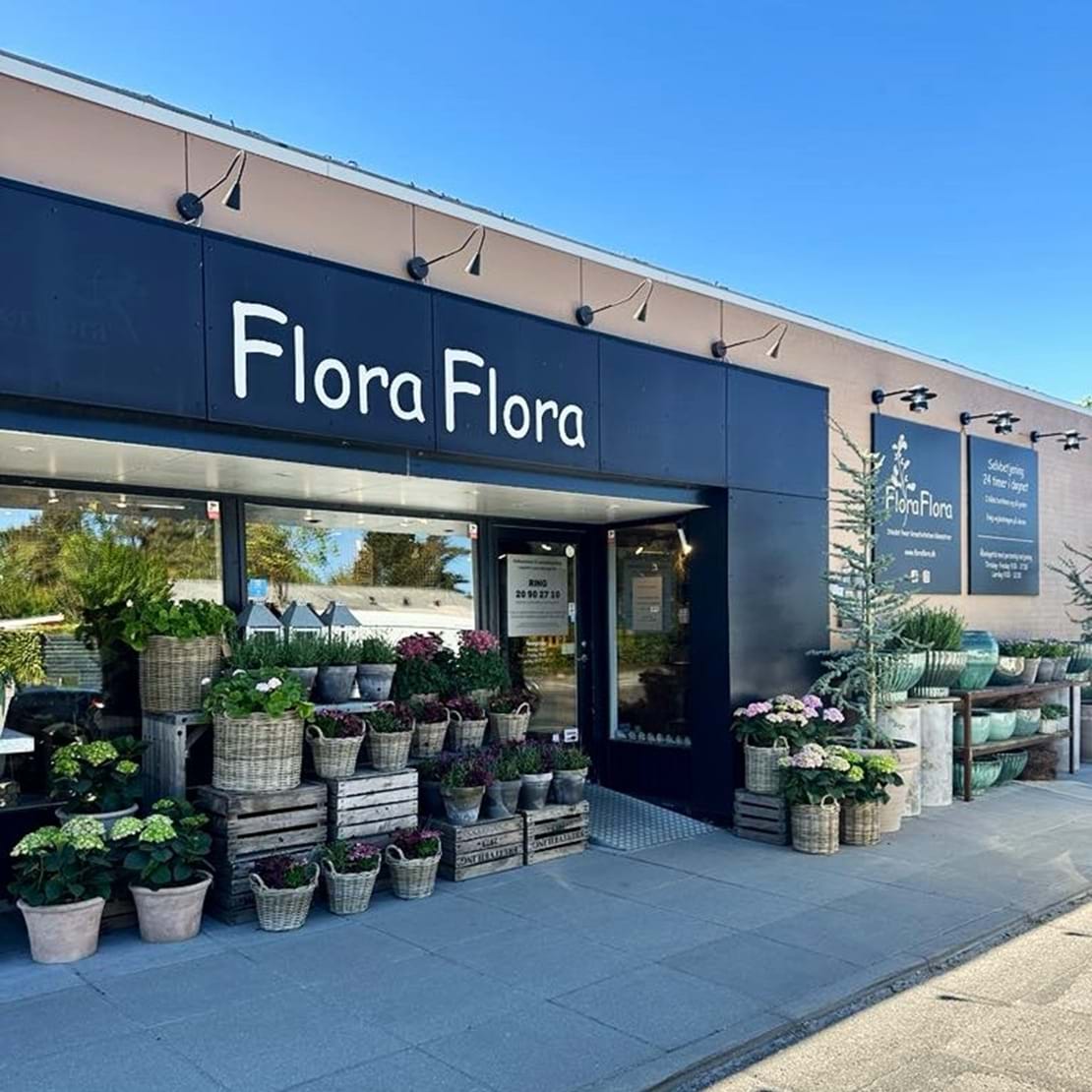 Facaden af blomsterbutikken Flora Flora i Elling, med en smuk pyntet gade.